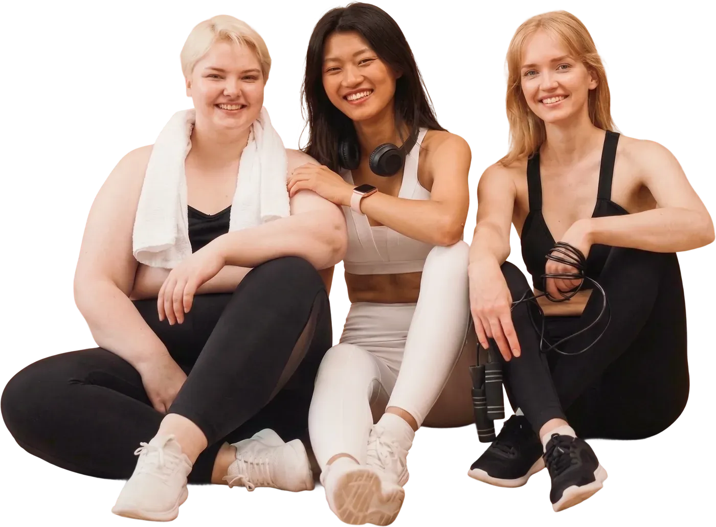 Three smiling women in sportswear sitting together